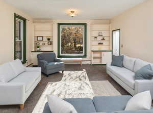 Carpeted living room featuring a baseboard radiator