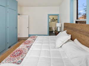 Bedroom featuring hardwood / wood-style floors and ensuite bath