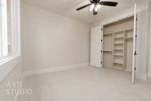 Unfurnished bedroom with ceiling fan, a closet, and light colored carpet