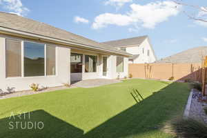 Rear view of property with a patio area and a yard