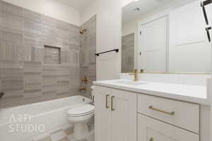 Full bathroom featuring toilet, tiled shower / bath, and vanity