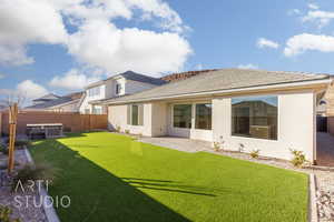 Rear view of property featuring a yard and a patio