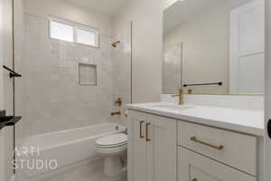 Full bathroom featuring tile patterned floors, toilet, vanity, and tiled shower / bath