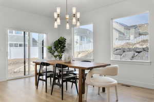 Dining area featuring light wood-type flooring and a chandelier