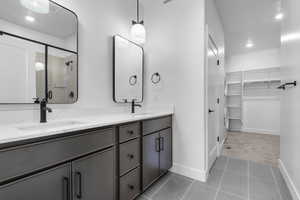 Full bath featuring recessed lighting, double vanity, a stall shower, and a sink