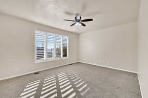 Spare room featuring ceiling fan and carpet flooring