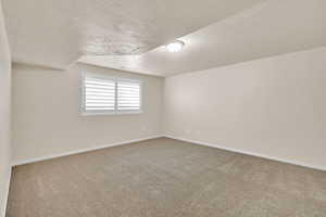 Carpeted spare room featuring a textured ceiling