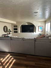 Living room featuring wood-type flooring and a textured ceiling