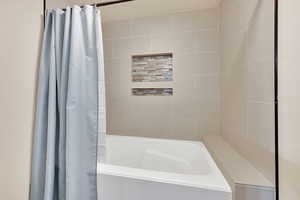 Bathroom featuring shower / bath combination with curtain