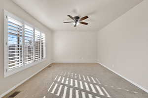 Carpeted empty room featuring ceiling fan