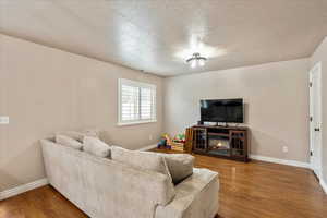Living room with wood finished floors and a textured ceiling