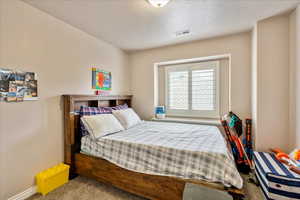 Carpeted bedroom with a textured ceiling