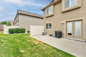Back of house with stucco siding and a patio