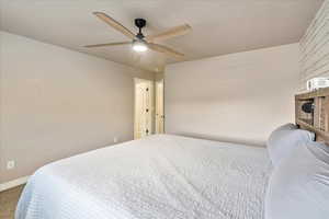 Carpeted bedroom with baseboards and ceiling fan