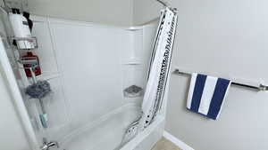 Bathroom featuring shower / tub combo and tile patterned flooring