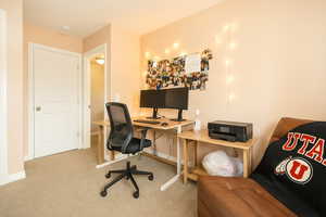 Carpeted home office featuring baseboards