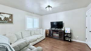 Living room with a textured ceiling and hardwood / wood-style floors