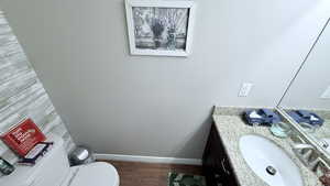 Bathroom featuring hardwood / wood-style floors, toilet, and vanity