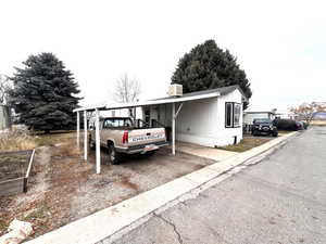 View of front of house featuring cooling unit and a carport