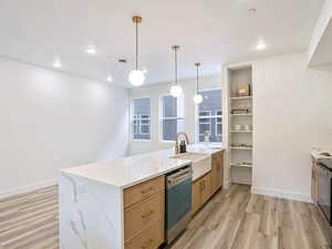 Kitchen featuring light brown cabinetry, dishwasher, a sink, light wood-type flooring, and a peninsula