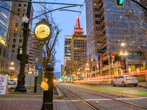 View of road featuring street lighting, a city view, and sidewalks