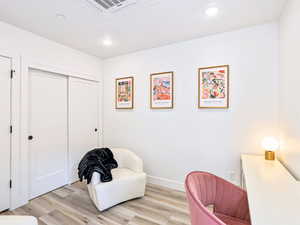 Living area featuring baseboards, light wood finished floors, and recessed lighting