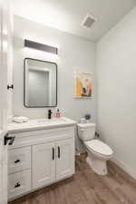 Bathroom with wood-type flooring, toilet, and vanity