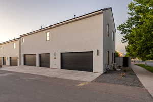 Property exterior at dusk with a garage and central air condition unit