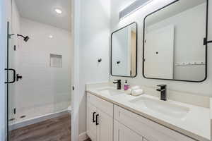 Bathroom with toilet, a shower with door, hardwood / wood-style flooring, and vanity