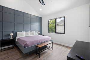 Bedroom with high vaulted ceiling and hardwood / wood-style floors