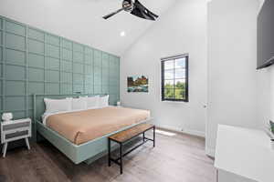 Bedroom featuring ceiling fan, hardwood / wood-style floors, and high vaulted ceiling