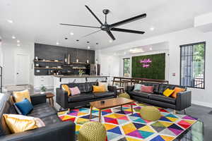 Living room with ceiling fan, concrete flooring, and a healthy amount of sunlight