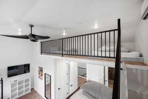 Stairway with ceiling fan and wood-type flooring