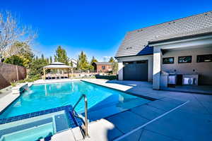 View of swimming pool with pool water feature, a gazebo, and a patio