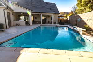 View of pool with pool water feature, a bar, and a patio