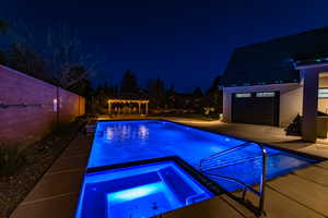 Pool at twilight featuring a gazebo, an in ground hot tub, and a patio