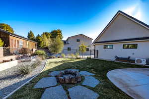 View of yard with ac unit, a fire pit, and a patio