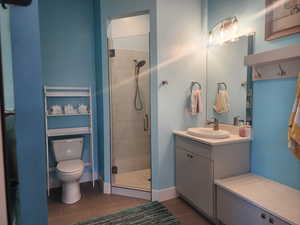 3/4 Bathroom off covered patio with toilet, tile patterned floors, walk in shower, and vanity