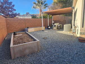 View of yard with cooling unit and raised garden beds.