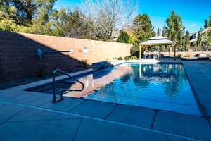 View of swimming pool with pool water feature and a gazebo