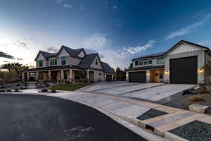 View of front of home with solar panels, covered porch, and a garage