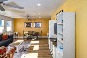 upstairs apartment over detached garage: Family room with ceiling fan, a textured ceiling, and dark hardwood / wood-style floors