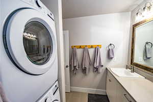 upstairs apartment over detached garage: 3/4 Bathroom featuring tile walk-in shower, stacked washer and dryer, tile patterned flooring, a textured ceiling, and vanity