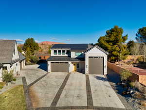 View of detached garage featuring a mountain view and solar panels