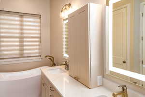 Owner's ensuite Bathroom featuring vanity and a free standing deep soaker tub.