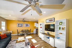 upstairs apartment over detached garage: Fiving room featuring ceiling fan, a textured ceiling, and light wood-type flooring