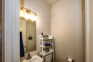 half Bathroom off kitchen featuring sink and toilet