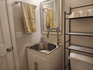 1/2 bathroom in detached garage with toilet and vanity