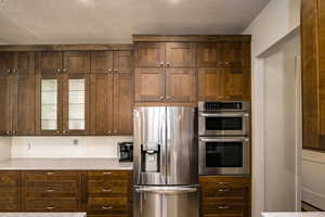 Kitchen featuring light countertops, a textured ceiling, and stainless steel appliances