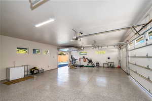 Garage with epoxy floors, garage door opener, and drive through garage bay to backyard.